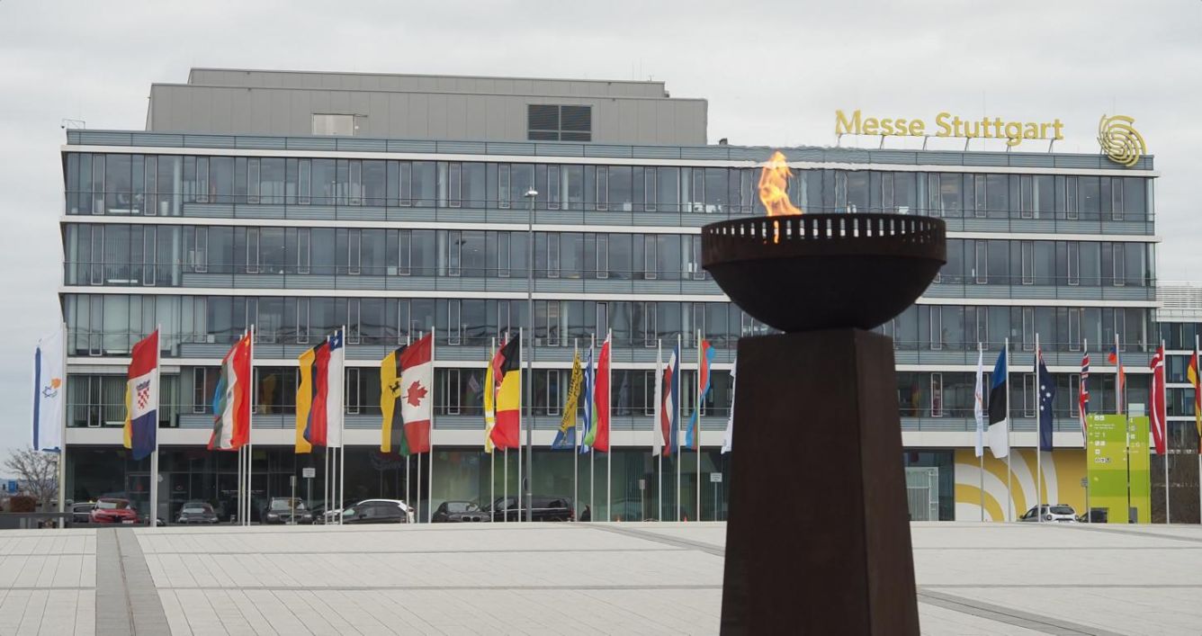 Olympisches Feuer und internationale Flaggen vor der Landesmesse Stutttgart